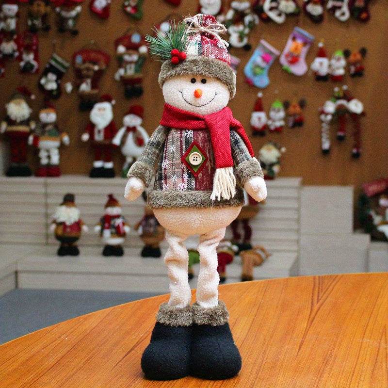 Festive Christmas decor fabric snowman figurine with scarf and hat standing on wooden table