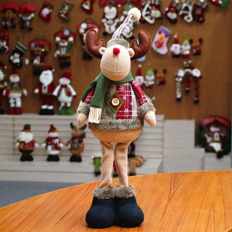 Fabric reindeer Christmas figurine wearing scarf and hat standing on wooden table festive Christmas decor