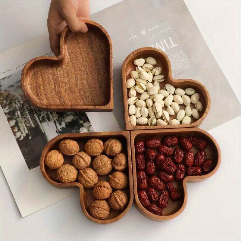 Walnut-colored heart-shaped wooden tray set holding nuts and dried fruits for serving