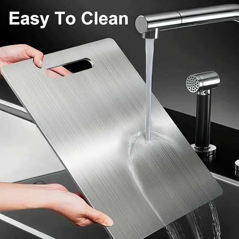 Premium high-quality stainless steel chopping board being rinsed under kitchen faucet for easy cleaning