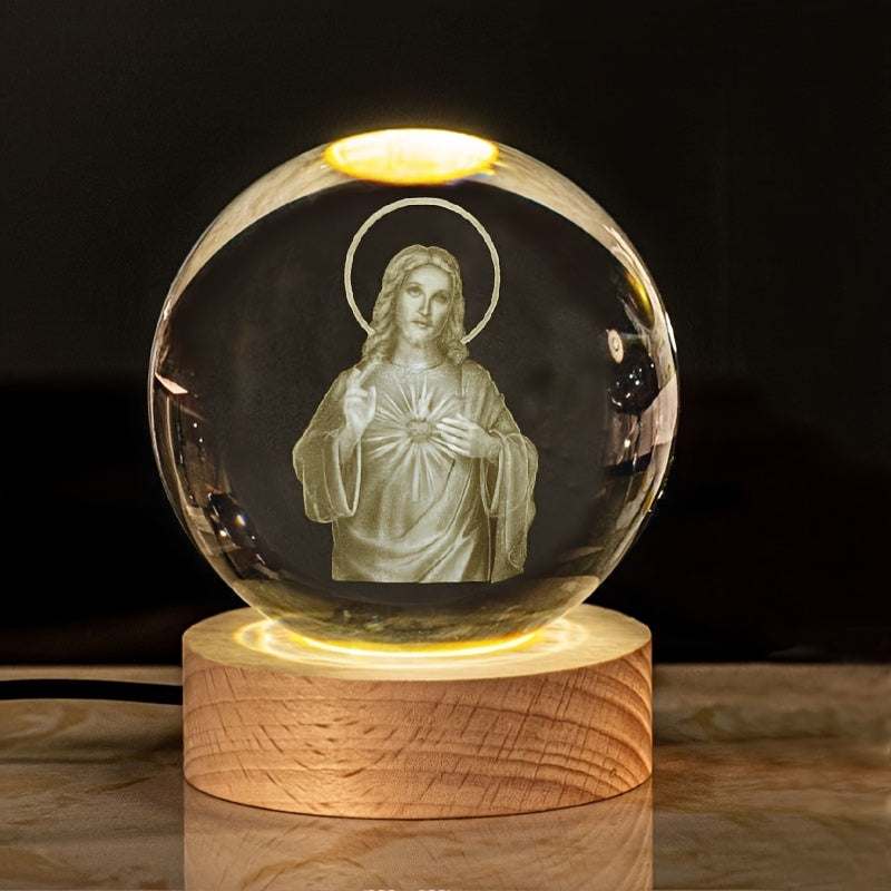 Luminescent crystal ball with 3D religious figure inside on wooden tabletop base nightlight