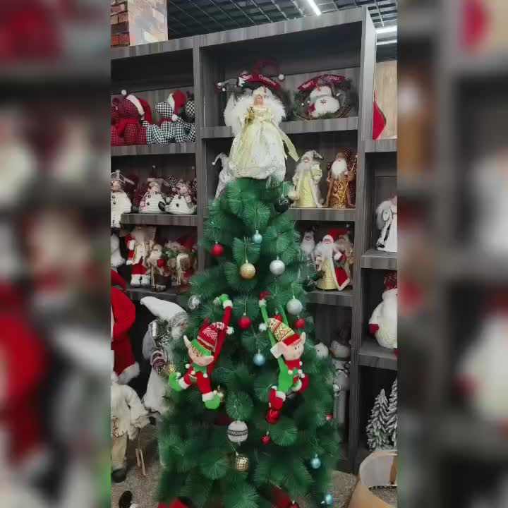 Christmas tree with angel topper and festive ornaments in holiday decor setting