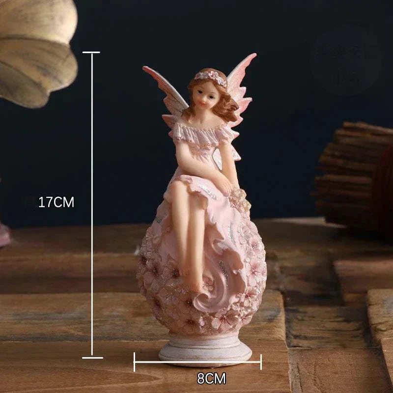 Nordic Beautiful Healing Girl Fairy Resin Ornament sitting on floral base, pink fairy figurine for home decor.