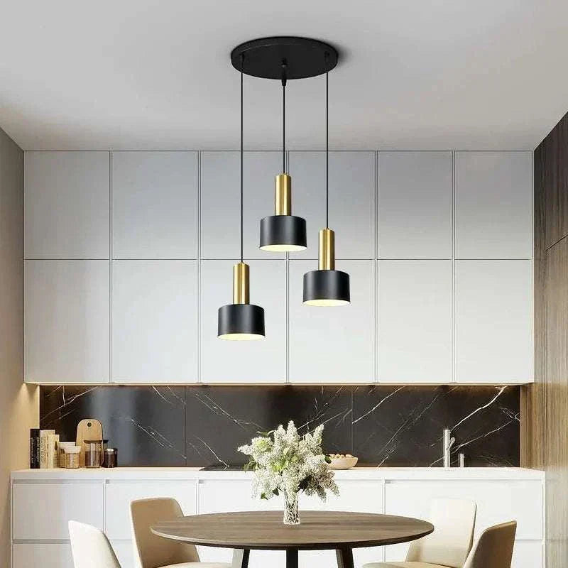 Nordic Simple Three-Chandelier Lamp with black and gold pendant lights over dining table in modern kitchen