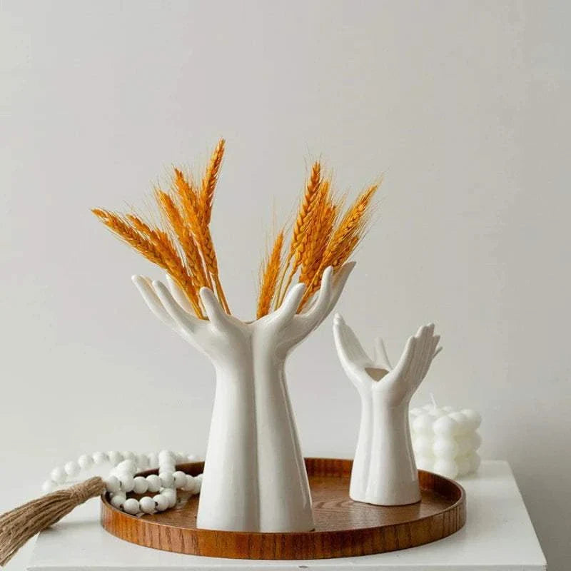 Modern ceramic hand-shaped vase with dried wheat bouquet on wooden tray for home decoration