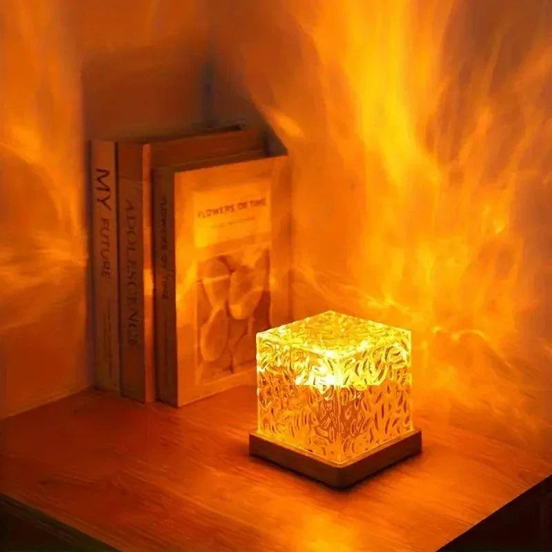 Northern Light starry sky and ocean wave projector lamp creating warm ambient light on wooden table near books