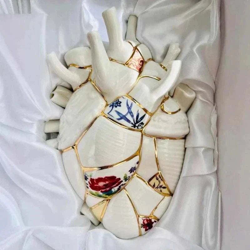 Ceramic Vase heart-shaped vase with painted floral porcelain patches and gold accents on white fabric background