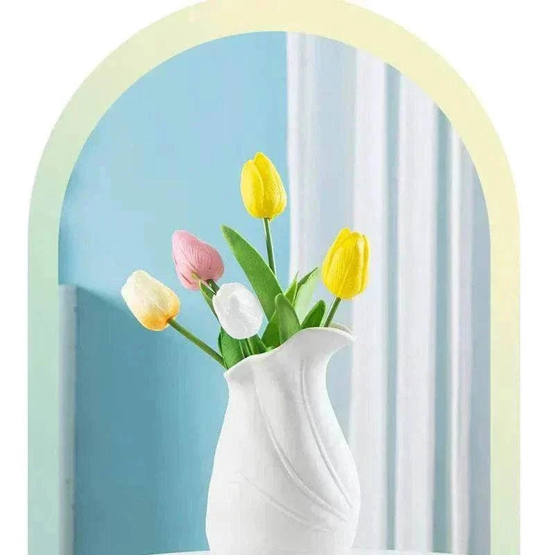 Modern ceramic vase with French minimalist and Nordic design holding colorful tulips against blue and white background