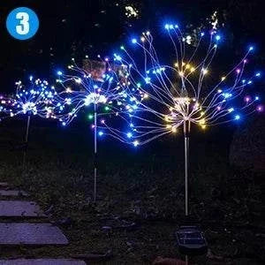 Solar firework string lights with colorful LED bulbs on stainless steel stakes glowing in garden at night