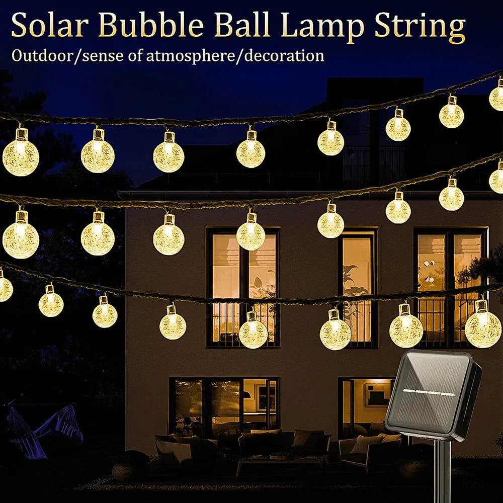 Solar Bubble Ball String Lights glowing warm white LED outdoor garden decoration with solar panel at night