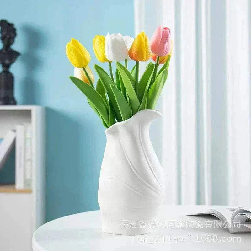 Modern ceramic vase with tulips in minimalist Nordic style on white table