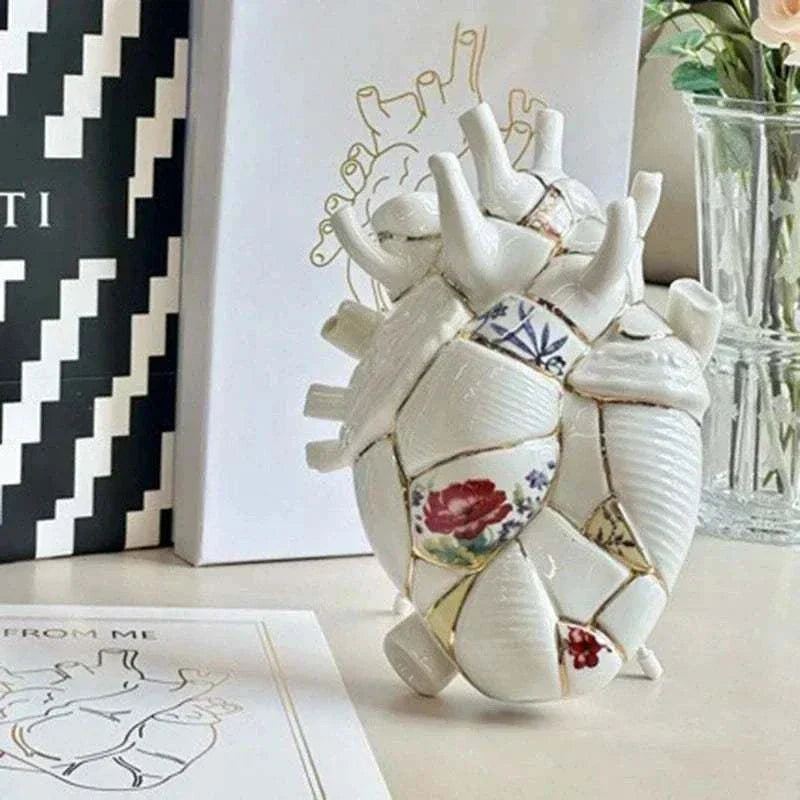 Ceramic vase shaped like an anatomical heart with floral and geometric painted pottery design for minimalist home decor