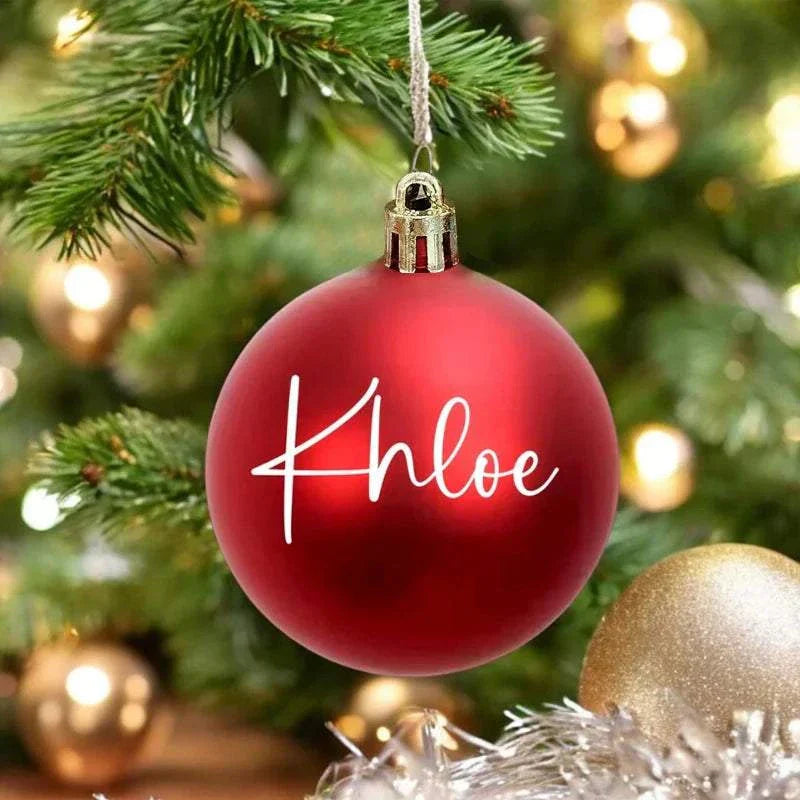 Personalized red Christmas ball ornament with name Khloe hanging on tree decorated for holidays