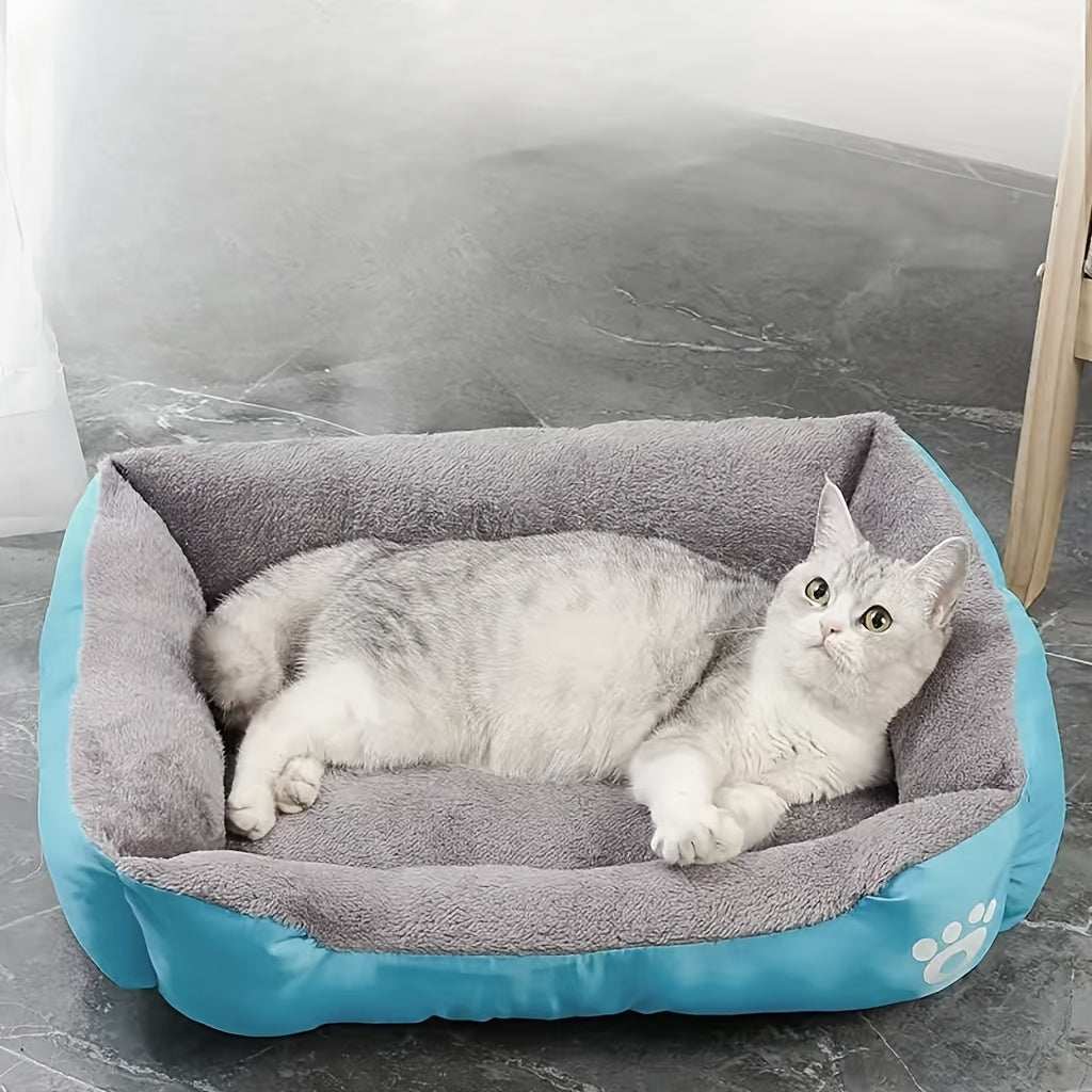 Large washable dog bed with paw print design, plush rectangular kennel in blue with gray interior, featuring a cat lying inside on a tiled floor.