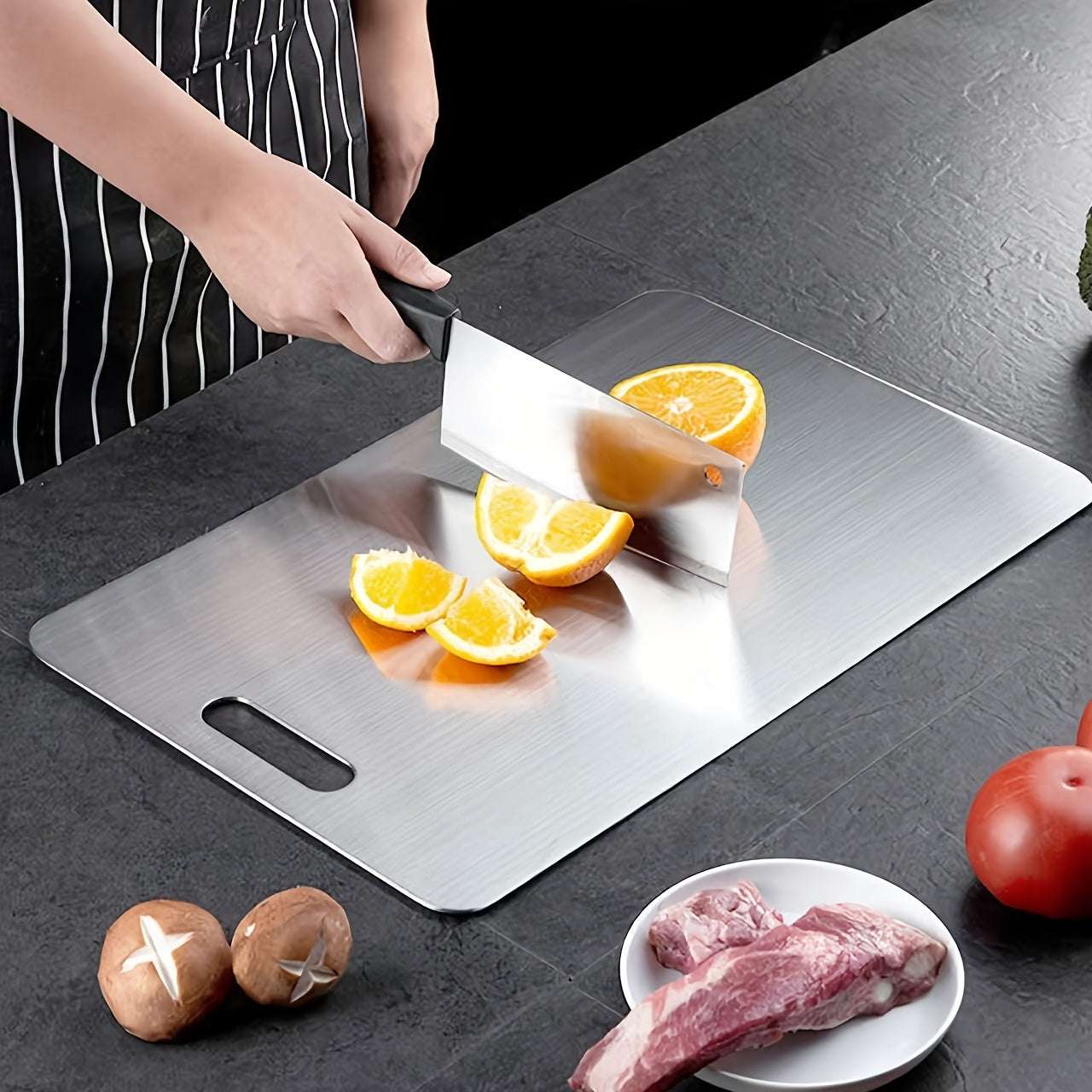 Premium high-quality stainless steel chopping board with handle, shown slicing oranges, suitable for kitchen prep and food safe