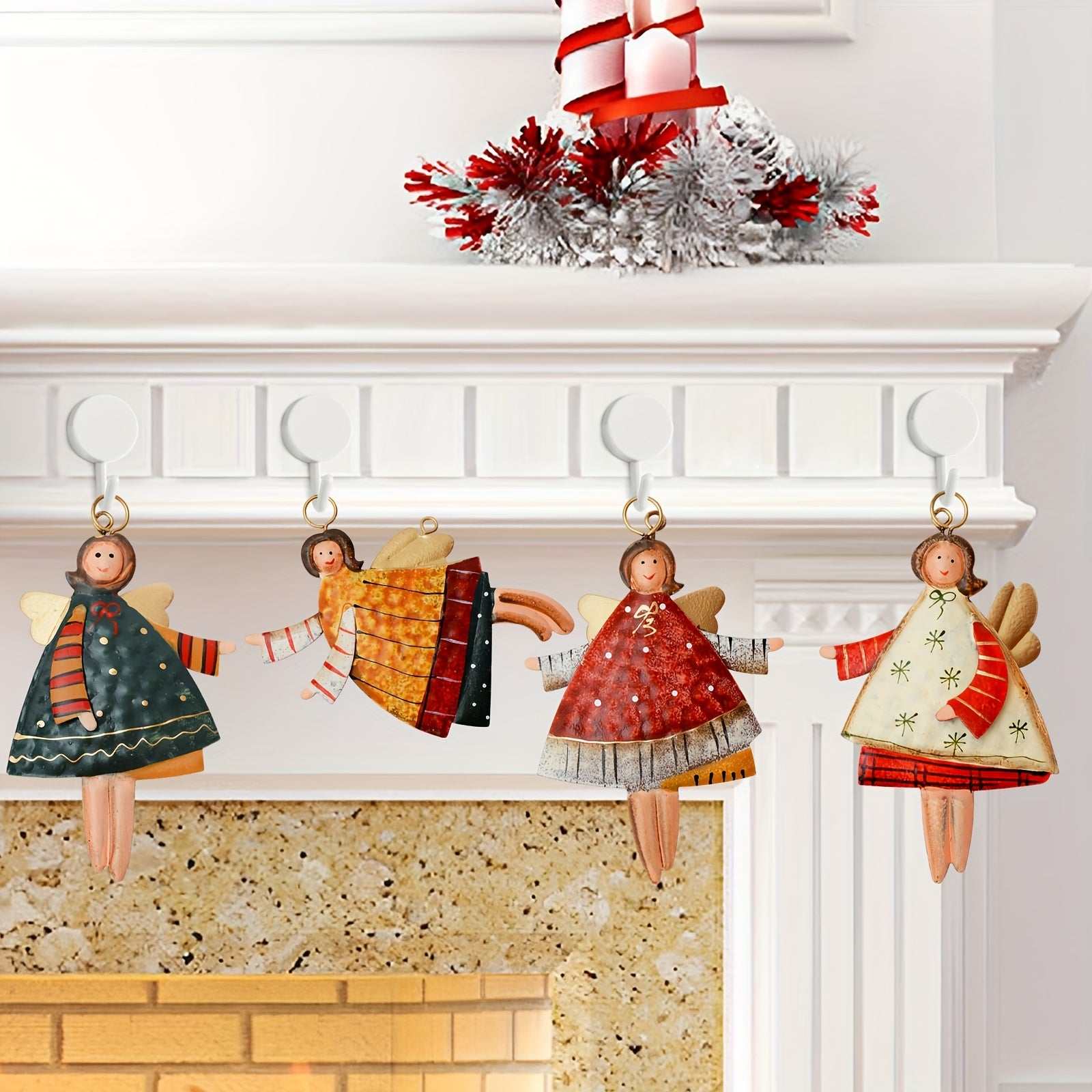 Set of 4 painted metal angel ornaments hanging from a white mantel, colorful vintage Christmas decoration with festive outfits and wings