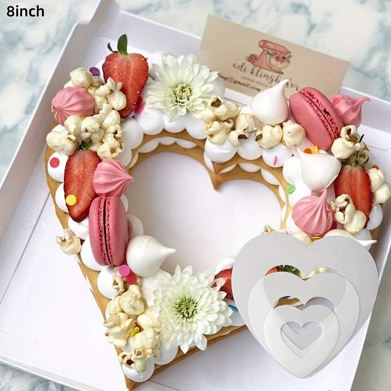 8-inch heart shape cake decorated with strawberries, macarons, meringue, popcorn, and flowers, along with white heart shape cake molds in various sizes
